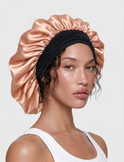 Model wearing a large black and pink mulberry silk bonnet to protect her hair from frizz, damage, and breakage.